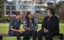 Adult talking with two teenagers at a park